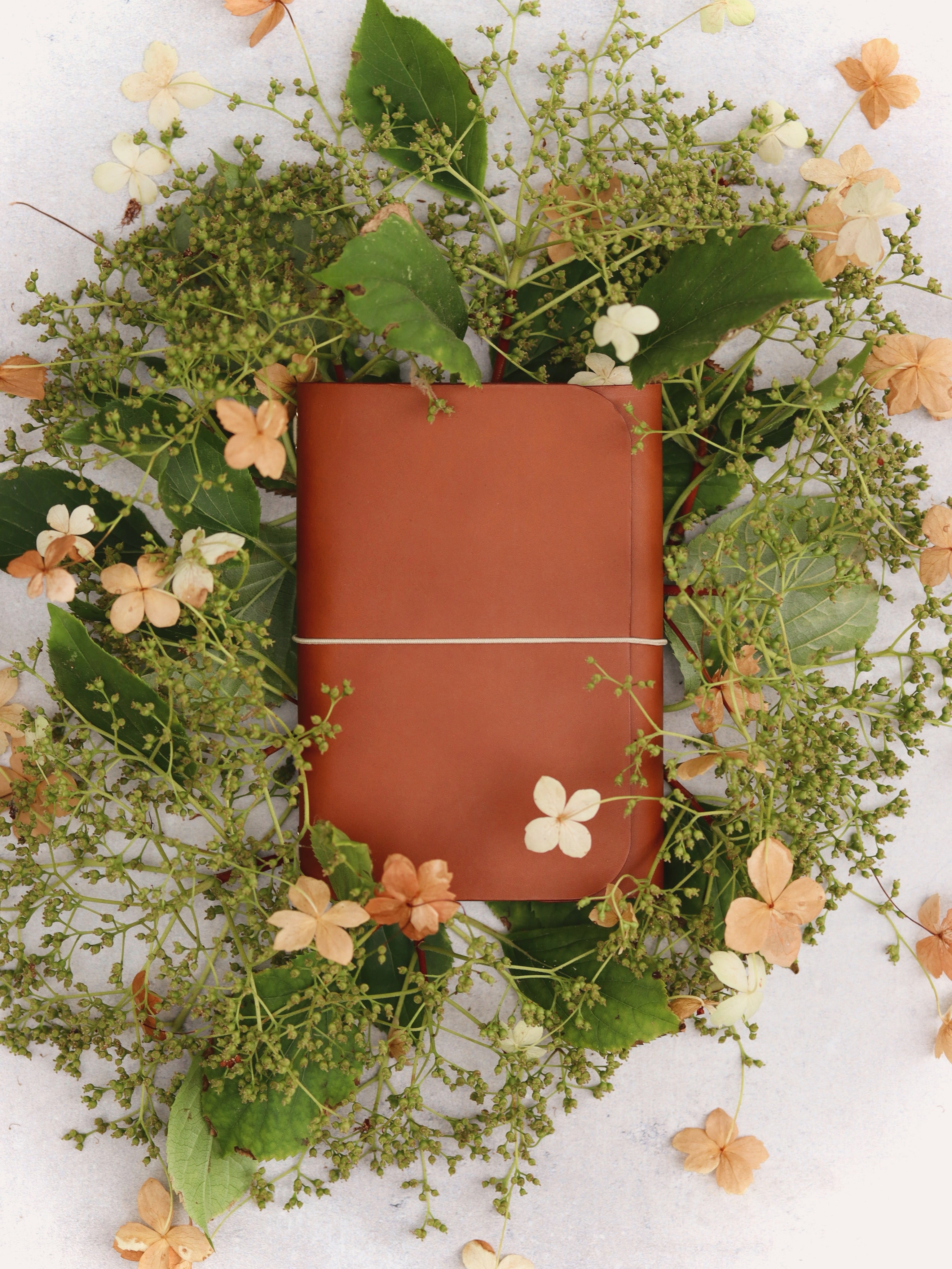 Marden cognac journal on a bed of green and brown hydrangea flowers