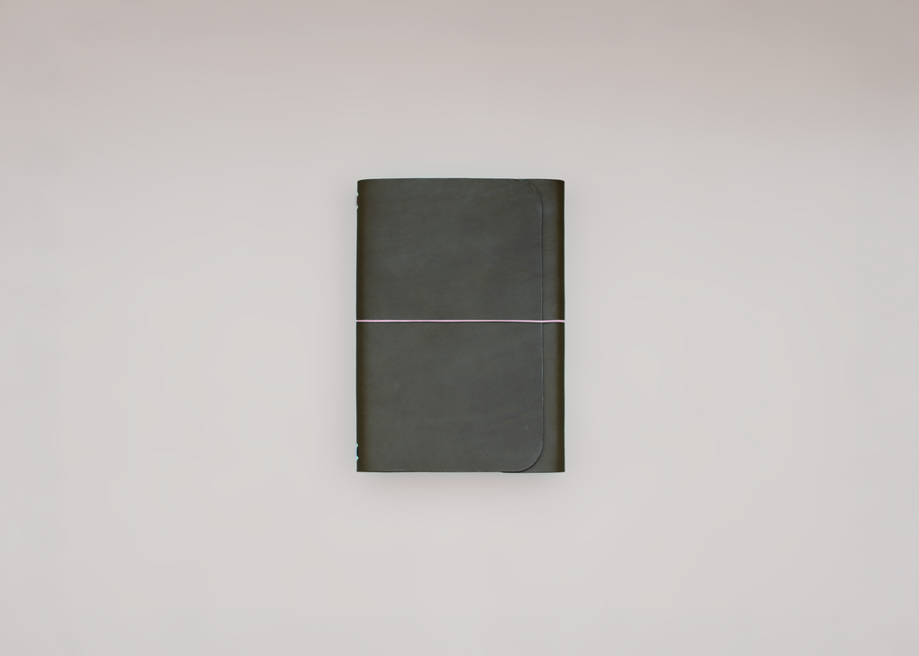 A dark olive green hardcover notebook with a thin elastic band closure, centered against a plain light gray background.